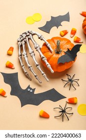 Paper Bats With Halloween Pumpkin, Skeleton Hand And Candy Corns On Beige Background