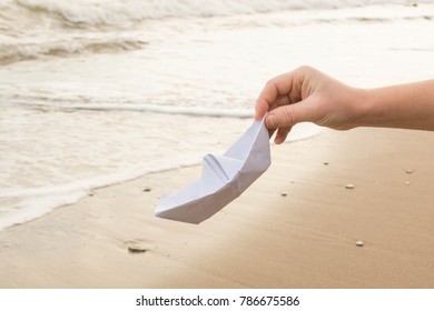 Paper Boat In Hand Against The Sea