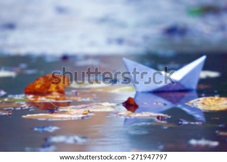 paper boat in a pool with leaves.autumn blurred photos for your design.autumn background