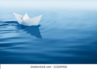 Paper Boat Sailing On Blue Water Surface