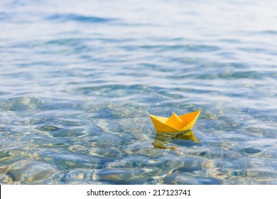 Paper Boat Sailing On Blue Water Surface 