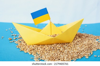 paper boat with Ukrainian flag, grain wheat and spikelets on a blue background. Ukraine grain problems of blockade of ports - Shutterstock ID 2179405761