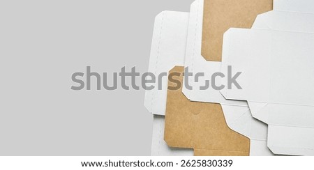 Paper box sheets. Opened cardboard boxes. Cardboard box layers background. Monochrome background, copy space. Sustainable packaging, artistic background. Transportation, packaging materials