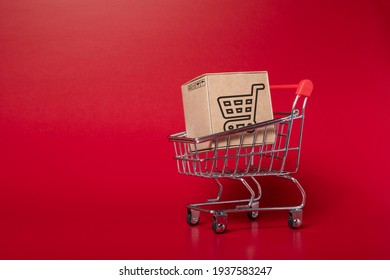 paper boxes parcel in a trolley isolated on red background. shopping online and service  home delivery.