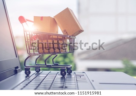 Paper boxes in a shopping cart on a laptop keyboard.Easy shopping with finger tips for consumers.Online shopping and delivery service concept.