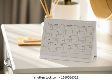 Paper calendar on white chest of drawers indoors