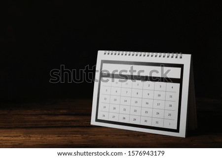 Paper calendar on wooden table, space for text. Planning concept