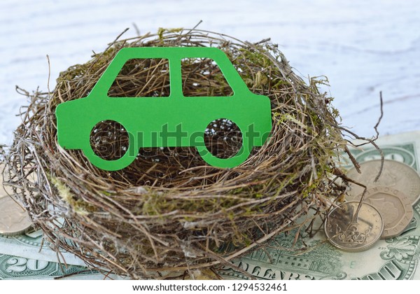 Paper car in nest on money background - Car\
insurance concept