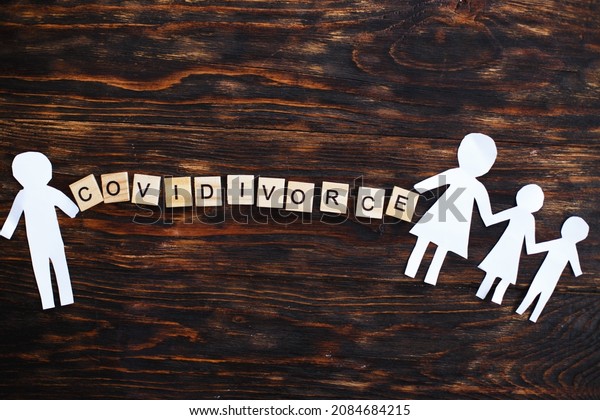 Paper chain cut family with broken\
heart on wooden background. divorce in the covid\
pandemic.