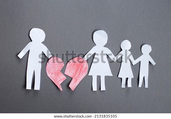 Paper chain cut family with broken\
heart on gray background. Divorce and broken family\
concept.