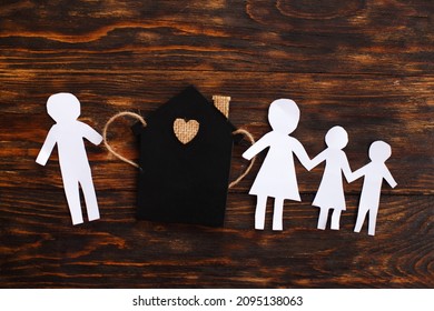 Paper Chain Cut Family Near Toy House On Wooden Background. Divorce And Broken Family Concept.