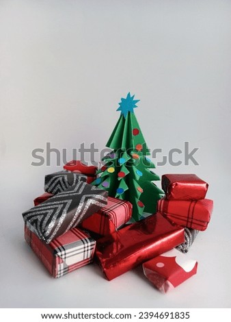 paper Chris tree surrounded by colourful gifts  on a white background 