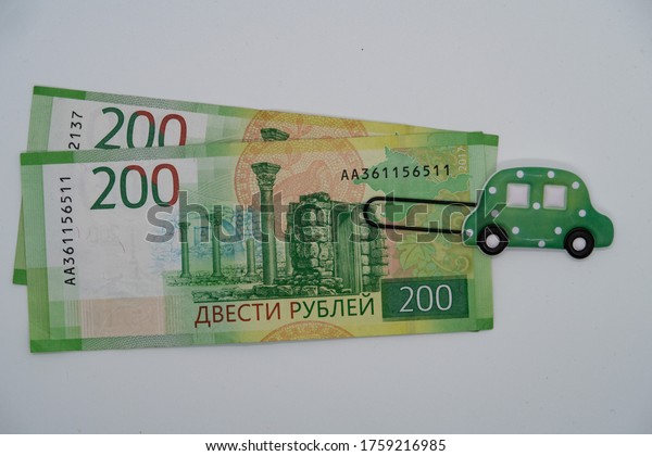Paper clip with the image of\
a toy car and a banknote, saving up money for a car, credit, car\
loan