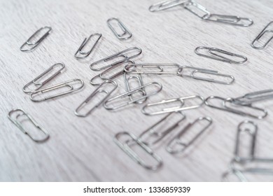 Paper clips scattered on a gray wooden surface - Powered by Shutterstock
