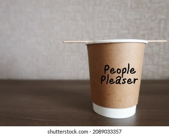 Paper Coffee Cup With Handwritten On The Side PEOPLE PLEASER, Concept Of One Who Tries Hard To Make Others Happy Even Go Out Of Their Way, Time Or Resources,overly Concerned With Pleasing Others