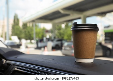 Paper Coffee Cup On Car Dashboard At Gas Station. Space For Text