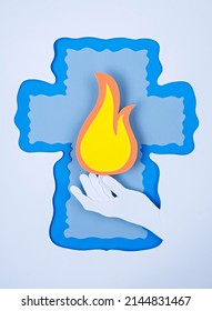 paper composition background for pentecost or trinity, hand holding tongue of flame in a frame in the shape of a cross