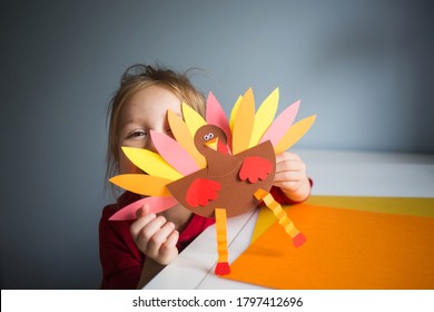 paper craft for kids. DIY Turkey made for thanksgiving day. create art for children. girl playing with a toy.