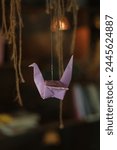 paper crane flying under the light