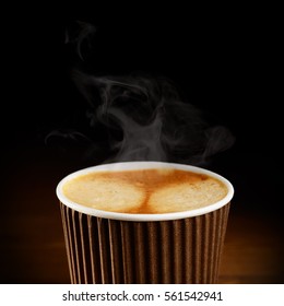 Paper Cup Of Coffee With Dark Blured Background As Empty Space. Drink To Go Or Take Away