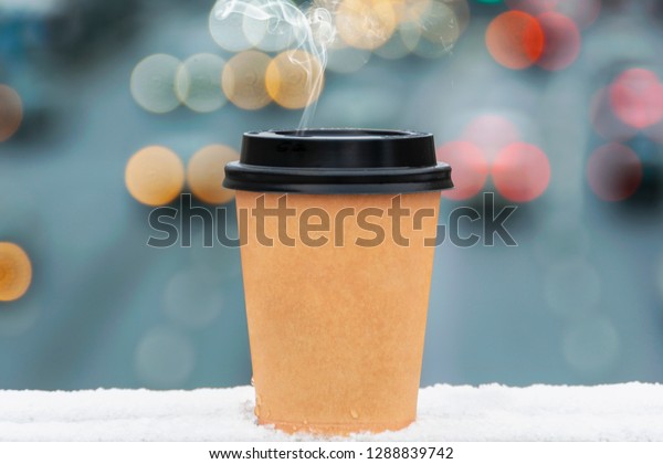 paper cup of coffee with a lid and smoke on a\
blurred background of the\
highway
