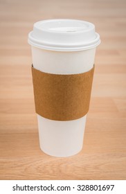Paper cup of coffee on wood background