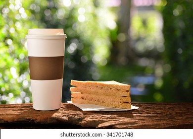 Paper Cup Of Coffee And Sandwich In The Garden