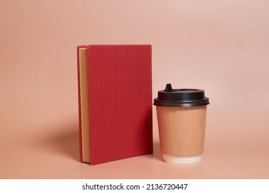 A paper cup of coffee stands next to a book on a colored background. Copy space - Shutterstock ID 2136720447