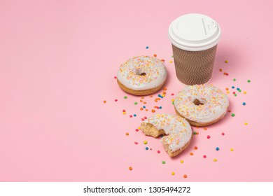 Paper cup with coffee or tea, Fresh tasty sweet donuts on a pink background. Fast food concept, bakery, breakfast, sweets, coffee shop. copy space.