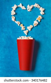 paper cup with popcorn on blue background. mock up. top view.