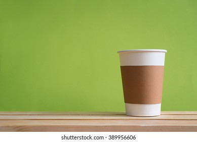 Paper Cup With Sleeve On Green Background