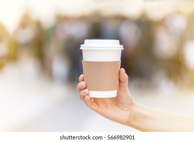 Paper cup of takeaway coffee in the hand. Place for your text or logo.