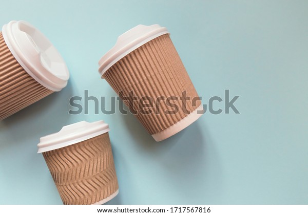 Paper cups of coffee to go on pastel background.\
Flat lay.