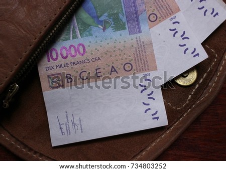 Paper currency F CFA (XOF) of the West African monetary union displayed in bills of 10,000 francs inside leather wallet
