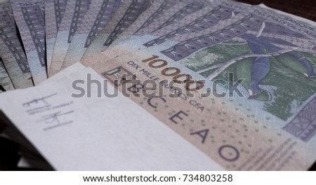 Paper currency F CFA (XOF) of the West African monetary union displayed in bills of 10,000 francs laid out in fan isolated on wooden background