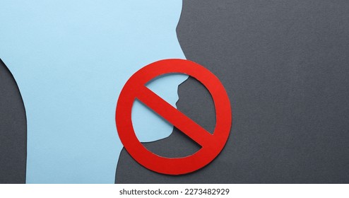 Paper cut face silhouette with prohibition sign on gray background. Prohibition of freedom of speech, censorship