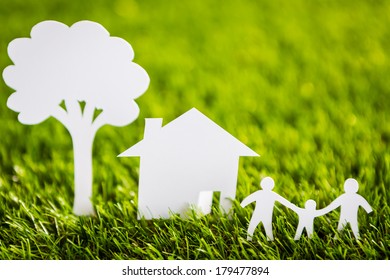 Paper Cut Of Family With House And Tree On Fresh Spring Green Grass