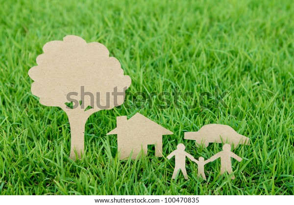 Paper cut of family with house , tree and car on\
fresh spring green grass