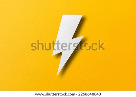 Paper cut lightning shape, lightning with light and shadow. placed on a yellow paper background
