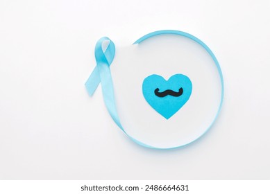 paper cut mustache on blue heart inside of blue large ribbon, prostate cancer awareness white background - Powered by Shutterstock