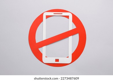 Paper cut Smartphone with red prohibition sign on yellow background. Ban - Shutterstock ID 2273487609