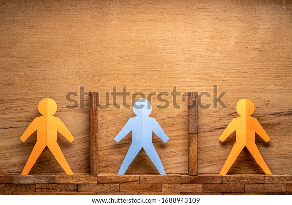 Paper cutout human figures separate by\
wooden blocks on wood background, social distancing during COVID-19\
virus outbreak concept with room for copy\
space
