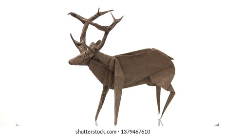 Paper deer figurine on white background. Paper animal isolated on white background. Beauty of handmade art.