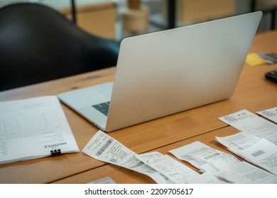 Paper documents and bills for paying online and computer on table in home office,Paper correspondence for managing budget or expenses,Finance concept.