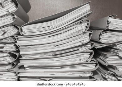 Paper documents stacked in archive. folders with documents on the shelves of archive room. Office shelves in the closet full of files - Powered by Shutterstock