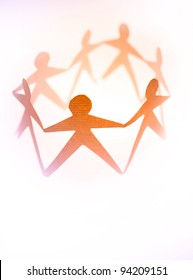 Paper Doll People In A Circle Holding Hands On Plain Background