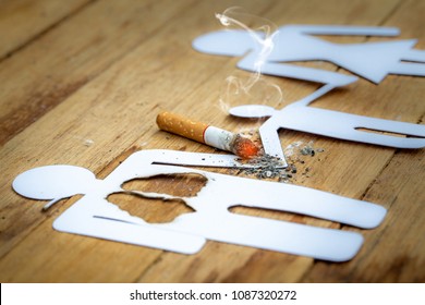 Paper dolls, parents, sons. The father doll has a burned lung. And his hand is holding hands with his son. It is burning because of cigarettes. There are flare and smoke.