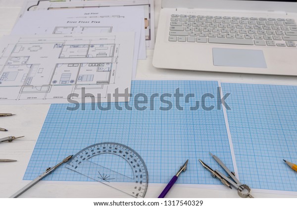 Paper for\
drafting and tools with laptop on\
desk