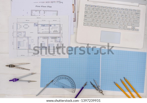 Paper for\
drafting and tools with laptop on\
desk
