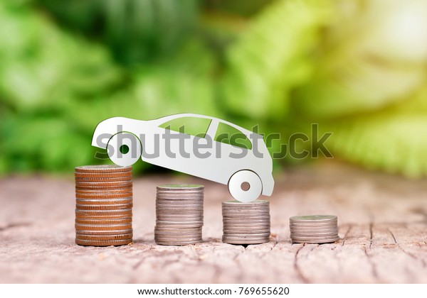 Paper eco\
car on coin stack, saving money for a car\
